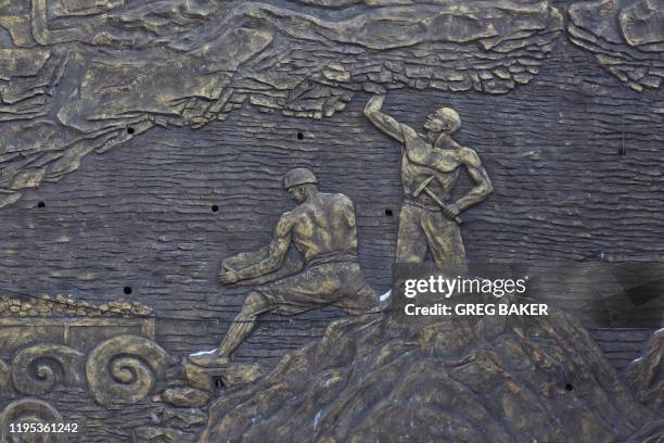 This photo taken on December 18, 2019 shows an art work depicting coal miners at a museum outside the closed Muchengjian coal mine in Mentougou, west...