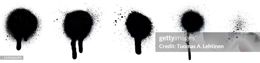 Close-up of several black spray paint spots, splashes and drips, isolated on white background.