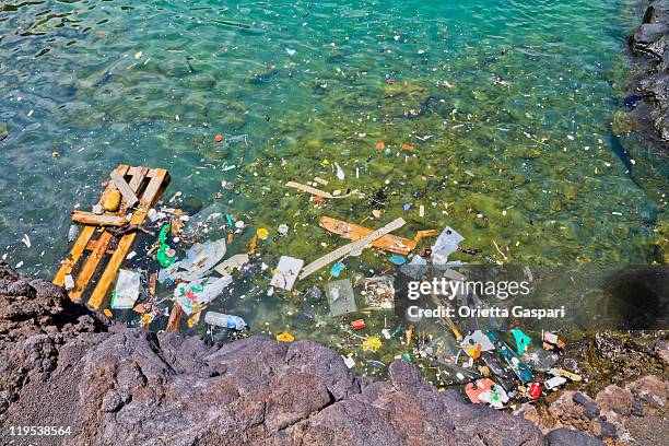 photo of garbage floating in the shoreline water - sea pollution stock pictures, royalty-free photos & images