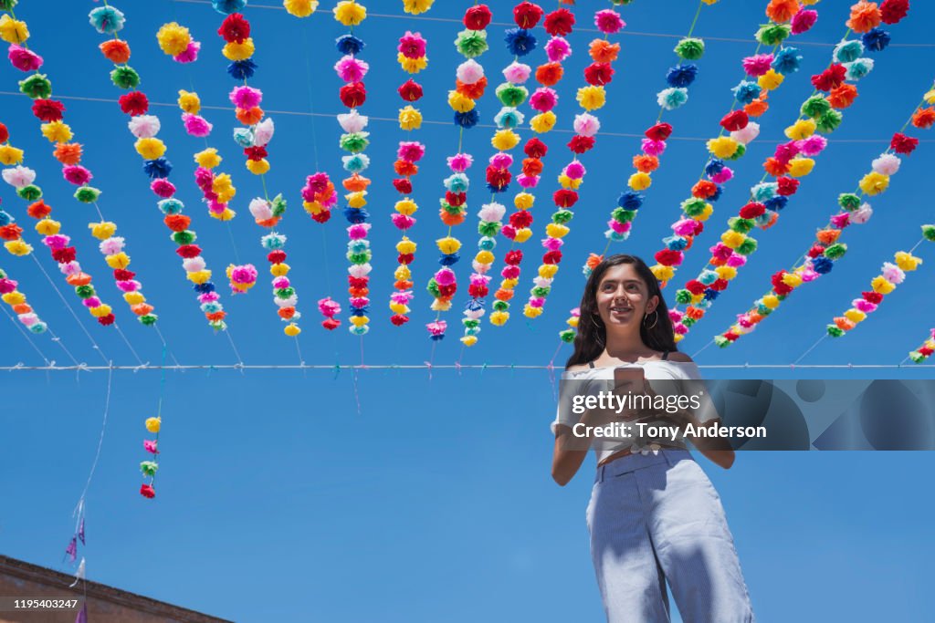 Teenage girl on street that's decorated for a festival