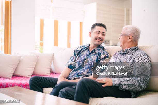 young adult happily talking with father in law - malay archipelago stock pictures, royalty-free photos & images