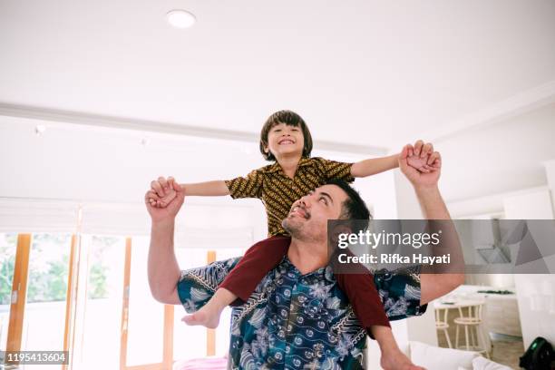 young asian father piggyback his son - malay archipelago stock pictures, royalty-free photos & images