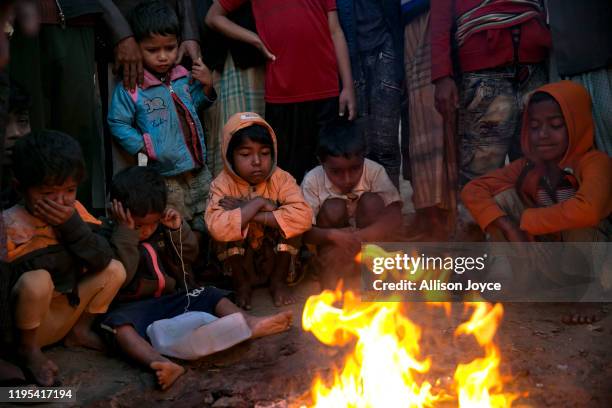 Children warm themselves by a fire in a Rohingya refugee camp on January 23, 2020 in Cox's Bazar, Bangladesh. On Thursday, the International Court of...