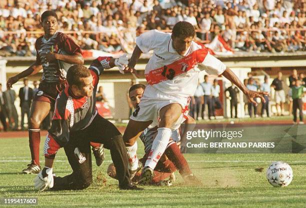 El atacante peruano German Carty pasa el arquero venezolano Rafael Dudamel bajo la mirada del defensor venezolano Alexander Echenique en el partido...