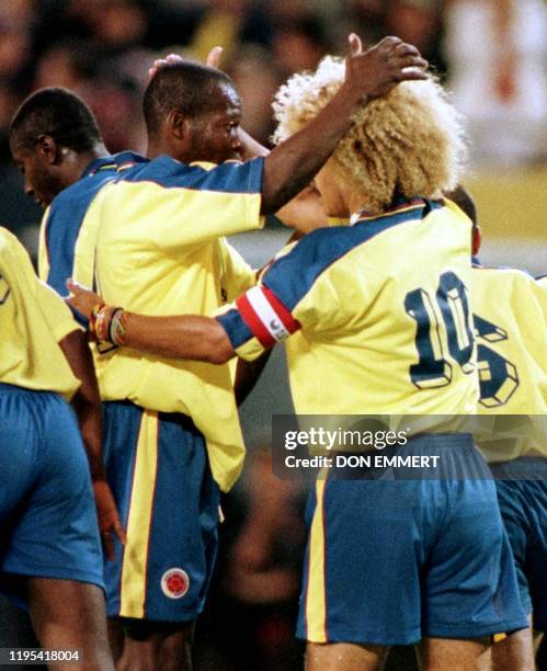 Colombia's Carlos Valderrama is congratulated by teammate Faustino Asprilla after making a free kick to score against Scotland goalkeeper Neil...
