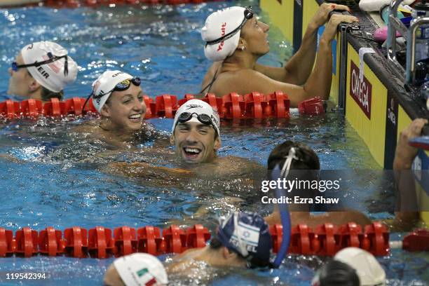 Michael Phelps and Rebecca Soni of the United States laugh as they wait on the wall during a swimming training session during Day Seven of the 14th...