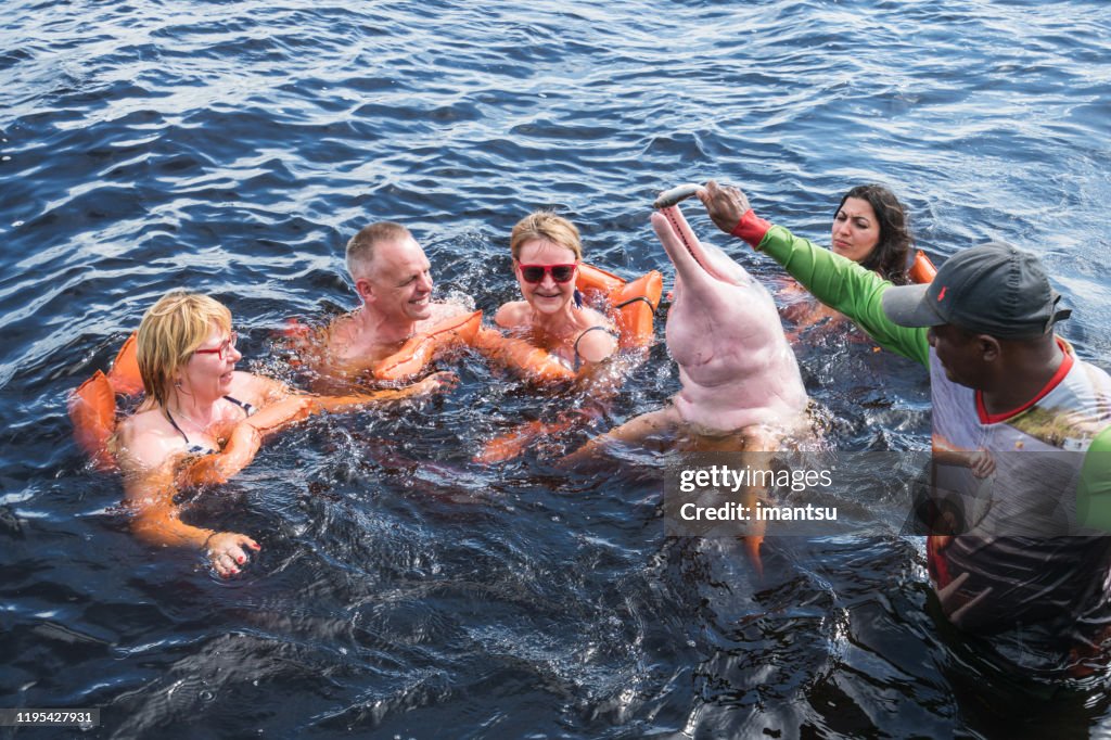 Tourists feeding the famous Pink Dolphin in Manaus, Brazil