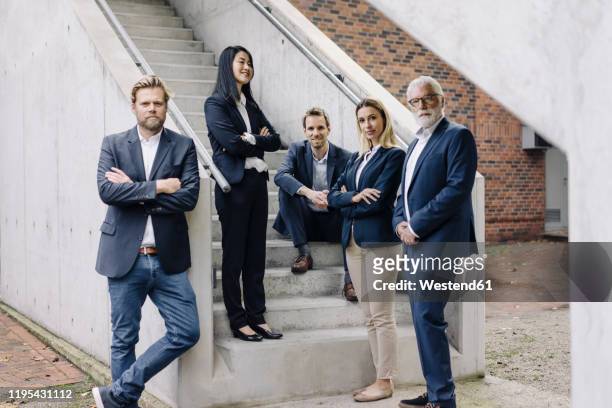 portrait of confident business people on exterior stair - fünf personen stock-fotos und bilder