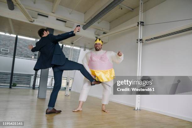 businessman kicking man dressed up as a ballerina in office - virilha humana - fotografias e filmes do acervo