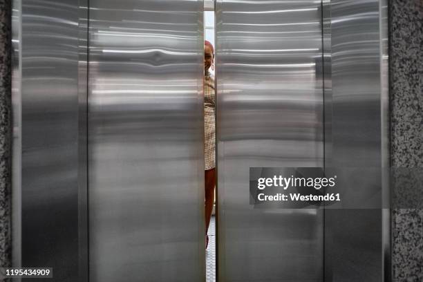 doors closing of an elevator with a young woman inside - door close stock pictures, royalty-free photos & images