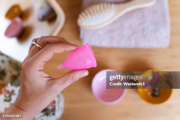 woman holding a menstrual cup - period cup stockfoto's en -beelden