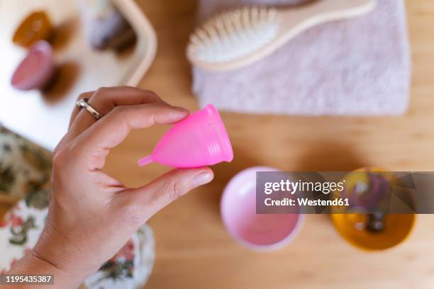 woman holding a menstrual cup - menstrual cup stock pictures, royalty-free photos & images