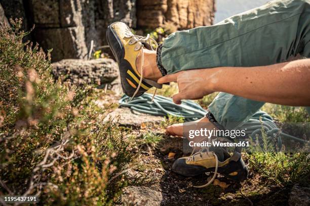 woman preparing to climb, tying climbing shoe - barfuß stock-fotos und bilder