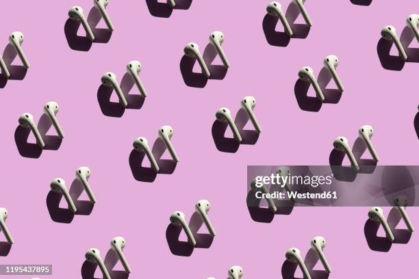 3d illustration of earphones on pink background - bluetooth stock-fotos und bilder