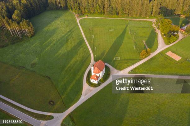 germany, upper bavaria, toelzer land, dietramszell, aerial view of st. leonhard church and soccer field - dietramszell stock-fotos und bilder