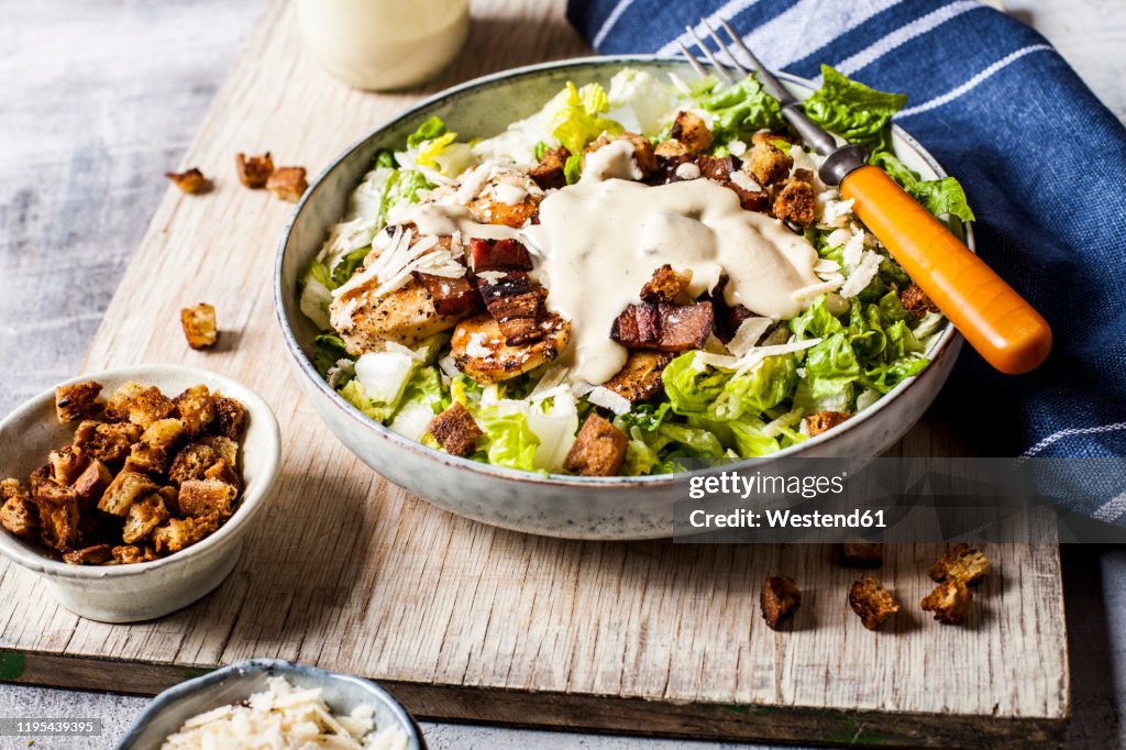 Bowl of Caesar salad with romaine lettuce, Parmesan†cheese, bacon, chicken breast and croutons