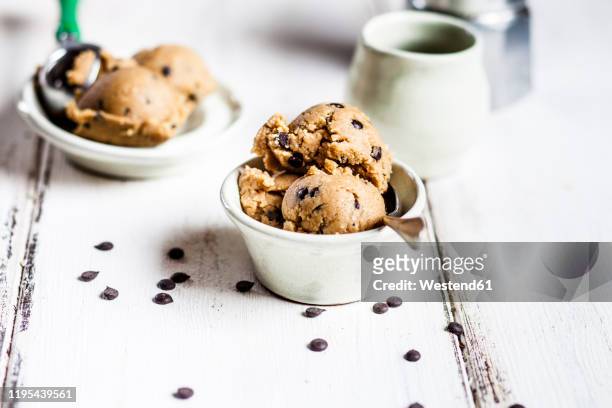 raw vegan chocolate chip cookie dough made from almond meal, coconut flour, coconut oil, chocolate chips and maple syrup - coconut biscuits stockfoto's en -beelden