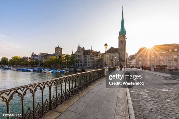 switzerland, canton of zurich, zurich,†munsterbrucke†bridge at sunset with†fraumunster†church in background - 蘇黎世 個照片及圖片檔