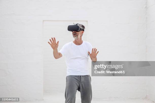 mature man discovering empty space with vr goggles - vr glasses stock-fotos und bilder