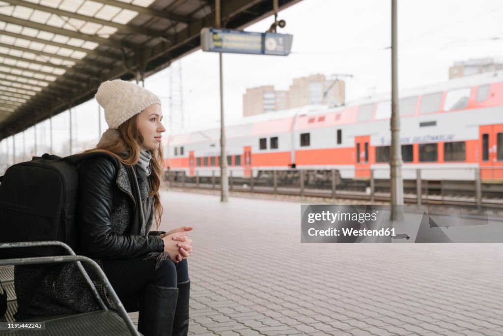 Young woman with backpack waiting on platform, Vilnius, Lithuania