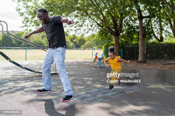 father and daughter playing hopscotch on a playground - hopscotch stock pictures, royalty-free photos & images