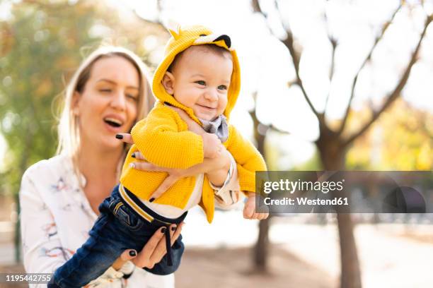 happy mother playing with baby boy in a park - 飛行機のまね ストックフォトと画像