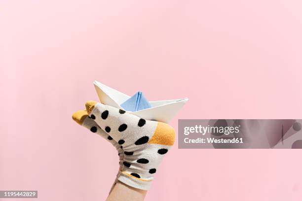 paper boat on the feet of a girl wearing dotted socks - pink sock image stock pictures, royalty-free photos & images