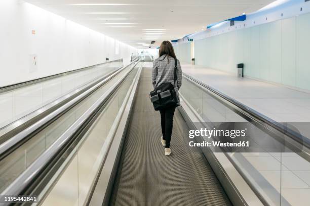 young businesswoman on moving walkway - travolator stock-fotos und bilder