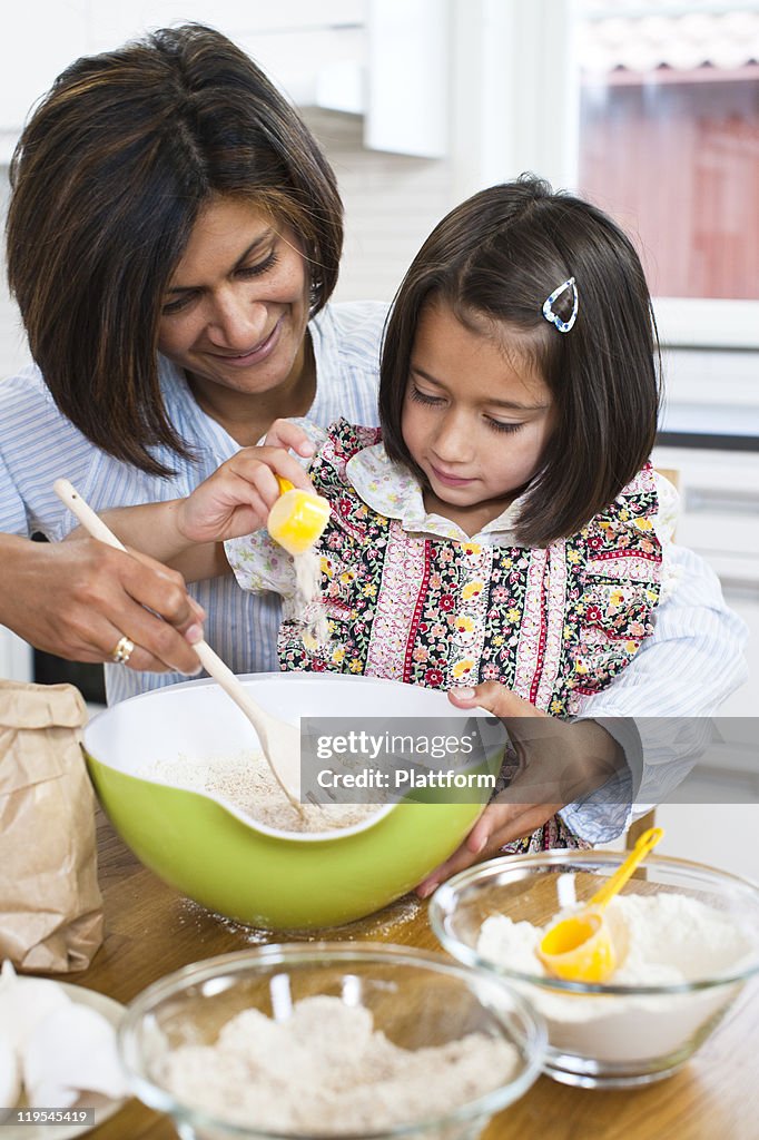 Mother baking with daughter in kitchen