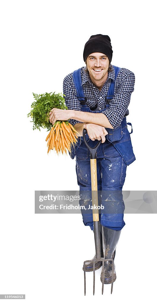 Studio shot of farmer holding carrots