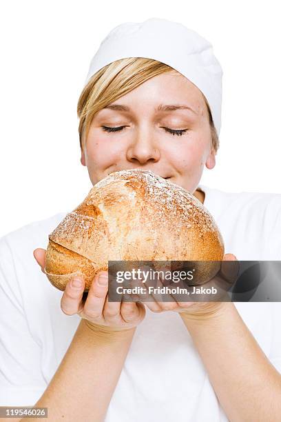 woman smelling fresh loaf of bread - baker smelling bread stock pictures, royalty-free photos & images