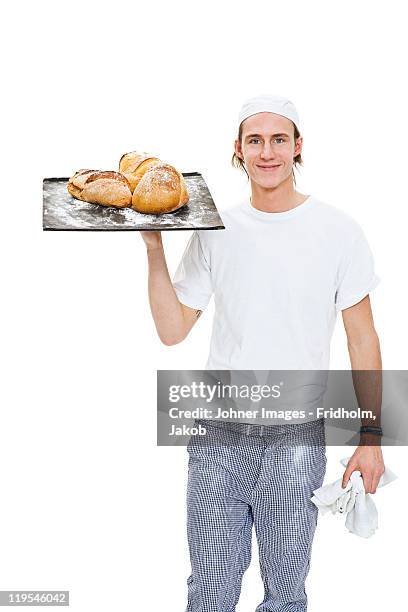 studio portrait of male baker holding tray with bread - beker stock pictures, royalty-free photos & images