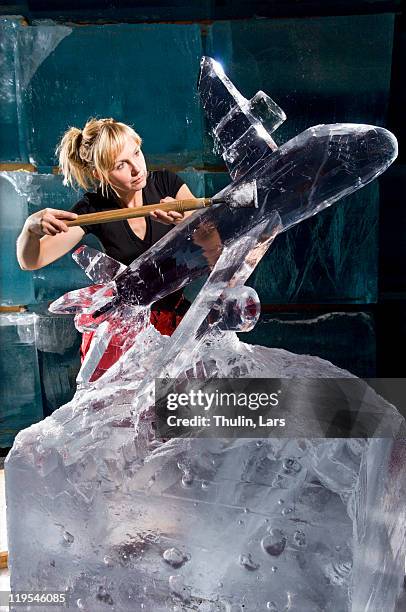 artist carving aeroplane out of ice block - ice sculpture stock pictures, royalty-free photos & images