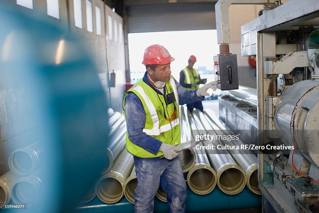 Workers using machinery in factory