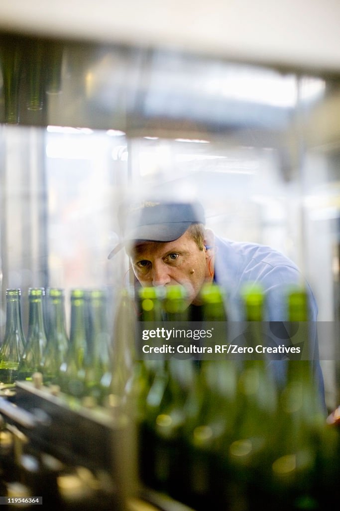 Workers examining bottles in factory