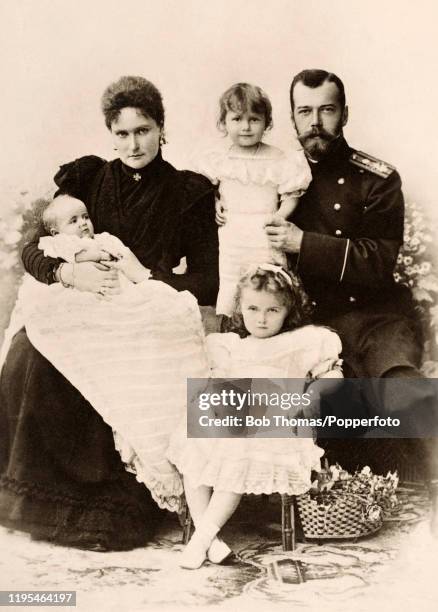 Vintage postcard featuring Tsar Nicholas II and Tsarina Alexandra of Russia with three of their daughters, left to right: Grand Duchess Maria, Grand...