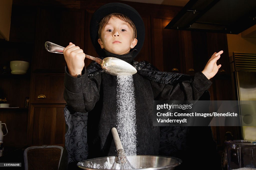 Boy magician cooking in kitchen
