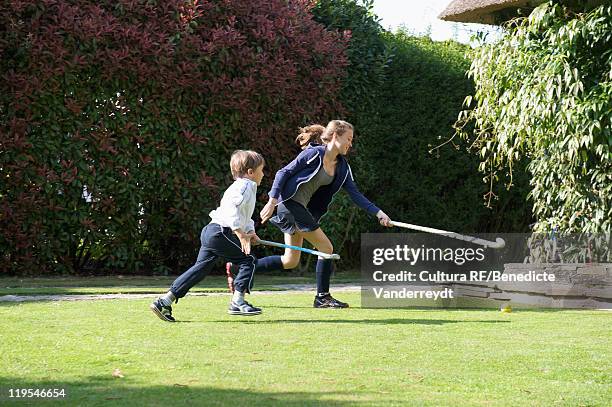 children playing hockey in backyard - hockey player stockfoto's en -beelden