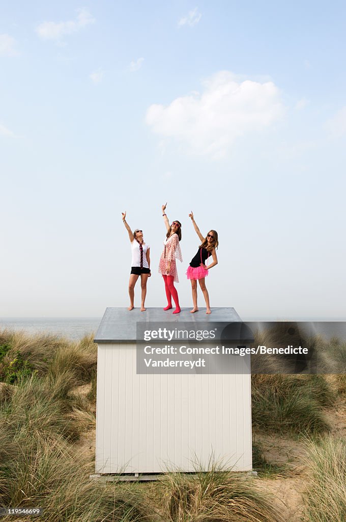 Teenage girls standing on beach hut