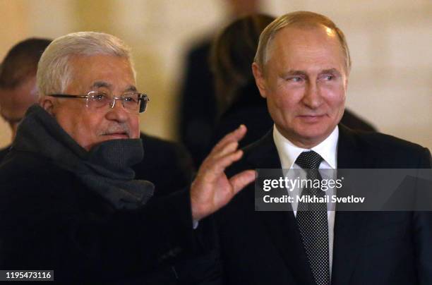 Russian President Vladimir Putin and Palestine's President Mahmoud Abbas wave during the welcoming ceremony at Presidental Palace in Bethlehem,...