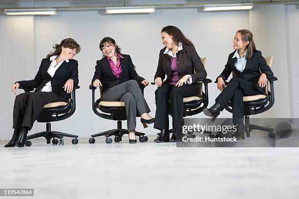 four businesswomen sitting in office chairs - massachusetts conference for women stock-fotos und bilder