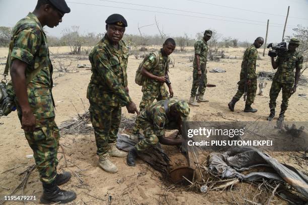 Commander Dick Ubi points to deep hole dug by vandals to steal oil from pipelines of the Nigerian National Petroleum Company close to Tarkwa Bay,...