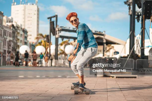 young skateboarder with a long board in marco zero, recife, pernambuco. - skate sports footwear stock pictures, royalty-free photos & images