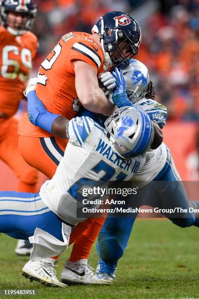 Jeff Heuerman of the Denver Broncos is tackled by Damon Harrison of the Detroit Lions and Tracy Walker during the fourth quarter of Denver's 27-17 on...