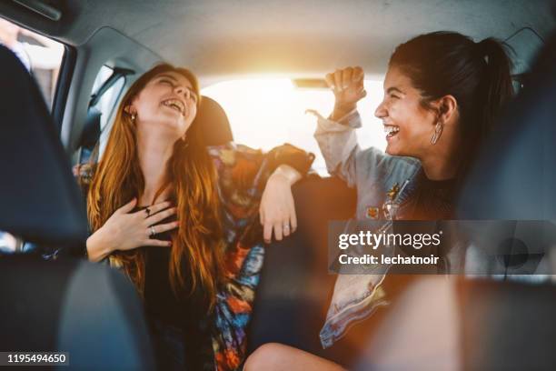 two girls in the backseat of a ride share in buenos aires - back seat stock pictures, royalty-free photos & images