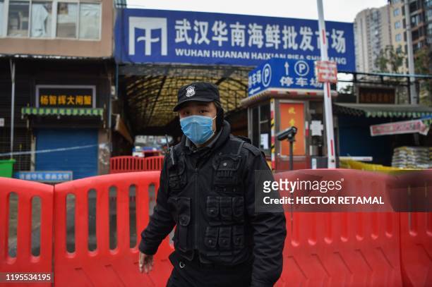Police officer stands guard outside of Huanan Seafood Wholesale market where the coronavirus was detected in Wuhan on January 24, 2020. - The death...