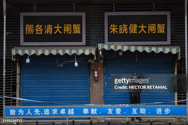 Security guard stands outside the Huanan Seafood Wholesale Market where the coronavirus was detected in Wuhan on January 24, 2020 - The death toll in...