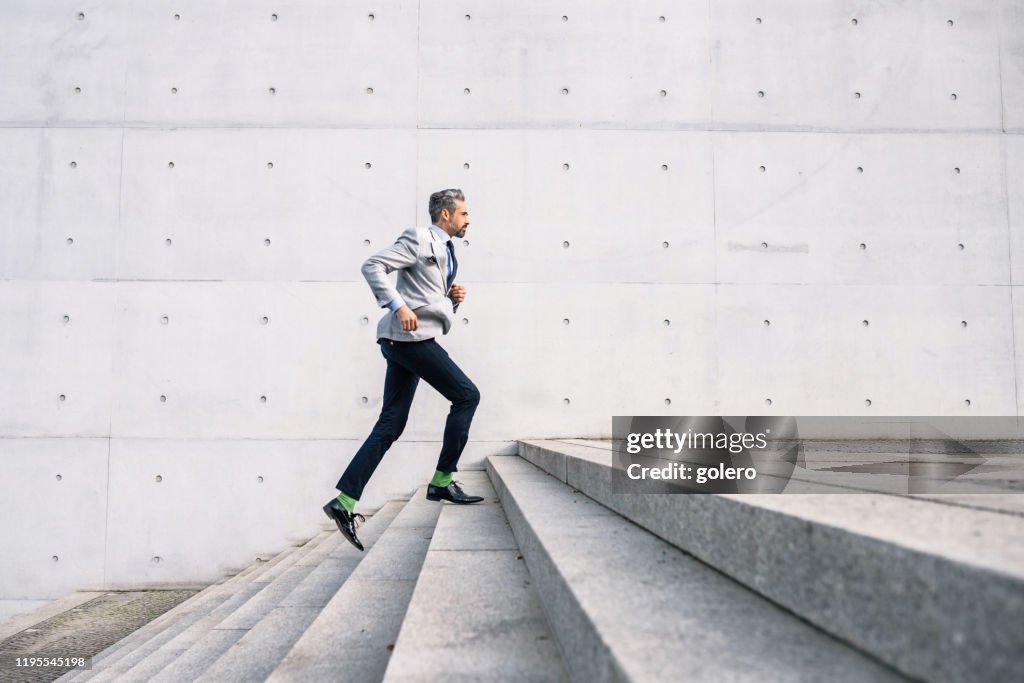 Empresario corriendo por las escaleras al aire libre