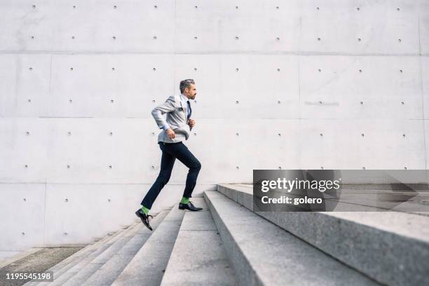 empresario corriendo por las escaleras al aire libre - escalón y escalera fotografías e imágenes de stock