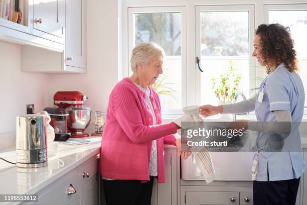 geheugen taken voor senior woman - huishoudelijke dienstverlening stockfoto's en -beelden